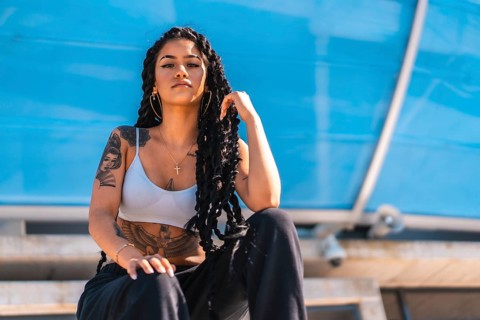Young black woman with long braids and tattoos