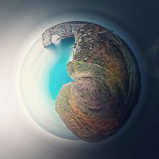 Sightseeing panoramic view to the Porte d'Aval arch cliff as a micro planet in space. Ocean waters continental side of Etretat