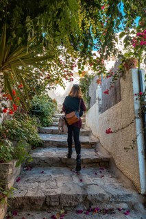 A young woman walking between houses in Mojacar with white houses on the top of the mountain. Costa Blanca in the Mediterranean Sea
