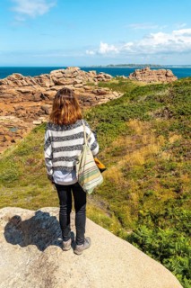 A young woman on the coast next to Lighthouse Mean Ruz
