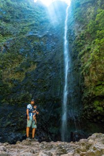 A father with his son at the waterfall at Levada do Caldeirao Verde