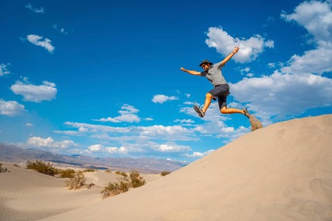 A young man jumping in desert on a summer afternoon in Death Valley
