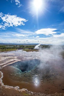 Geysir Strokkur with the sun in the background of the golden circle of the south of Iceland