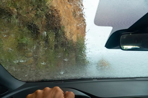 Water on top of the car driving inside a car at Anjos Waterfall