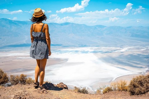 A young woman in dress on the beautiful viewpoint of Dante's view in Death Valley