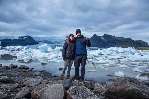 A couple with a backpack looking at the Jokulsarlon Ice Lake in the golden circle of southern Iceland