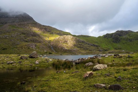 Lake Llyn Llydaw with Mount Snowdon behind clouds in late summer