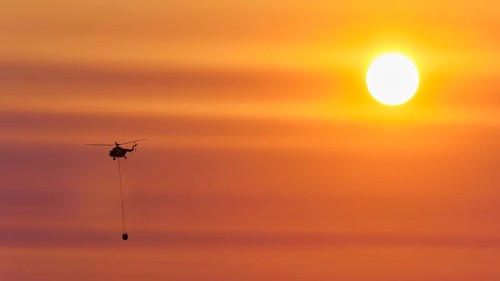 Firefighting helicopter in sunset