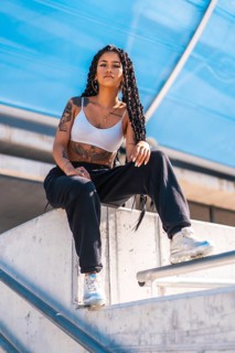 Young woman of black ethnicity with long braids and with tattoos