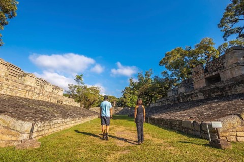 A couple strolling through the ball game in the temples of Copan Ruinas. Honduras