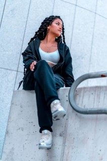 Urban session. Young woman of black ethnicity with long braids and with tattoos