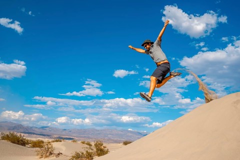 A young man jumping in desert on a summer afternoon in Death Valley