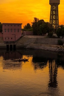 A town near the river at sunset on the Nile river cruise. Egypt. Sailing from Luxor to Aswan