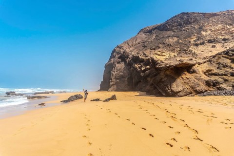 A young father in the Roque del Moro of the Cofete beach of the natural park of Jandia