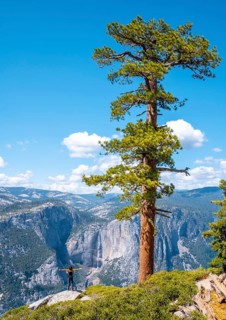 A young woman in Sentinel Dome looking at Upper Yosemite Fall