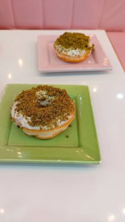 Two matcha flavored donuts in a cute pastel color themed cozy cafe