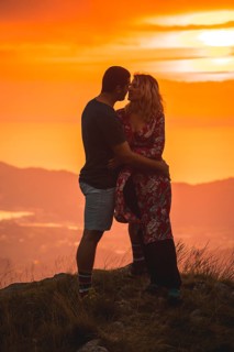 Parents with their son on top of a mountain at sunset