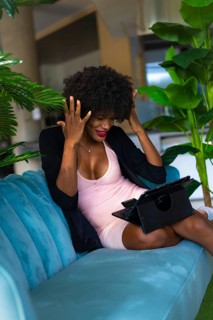 Young entrepreneur of black race and afro hair making a video call with great joy and amazement