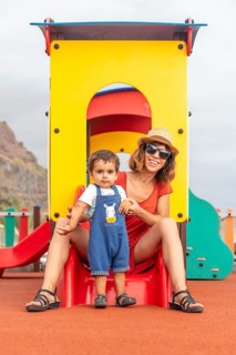 Baby playing in a playground having fun in summer
