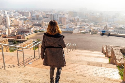 A young tourist walking in the viewpoint of Cerro San Cristobal and the city of Almeria in the background