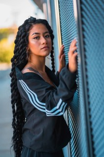Urban session. Young woman of black ethnicity with long braids and with tattoos