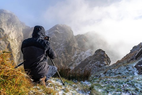 A photographer taking a photo with the tripod in the snowy winter sunset