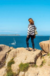 A young woman by the sea on the coast next to Lighthouse Mean Ruz
