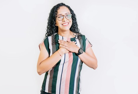 Positive smiling girl with hands on chest. Grateful people with hands on chest. Grateful young woman smiling with hands on chest isolated