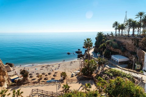 Calahonda beach in the town of Nerja with people sunbathing in spring
