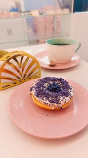 Ube or purple yam flavored donut in a cute pink pastel color themed cafe