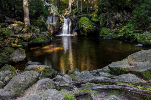 Waterfall in autumn forest with rocks
