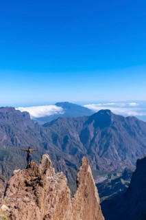 A young man after finishing the trek at the top of the volcano of Caldera de Taburiente near Roque de los Muchachos looking at the incredible landscape