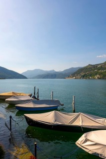 Port with Boats in Brusino Arsizio on the Waterfront in a Sunny Summer Day on Lake Lugano and Mountain View over Morcote
