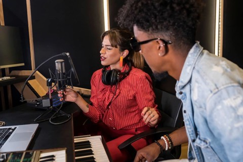 Female caucasian singer and black pianist recording a new album in studio
