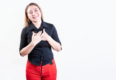 Thankful young woman with hands on chest. Grateful teenage girl smiling with hands on chest isolated. Positive latin girl with hands on chest
