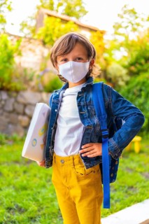 Caucasian child with face mask ready for back to school. New normality