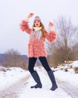 Blonde girl posing in a pink fur jacket