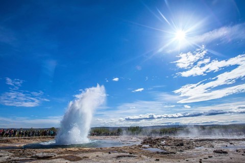 Water explosion in the Geysir Strokkur with the sun in the background of the golden circle of the south of Iceland