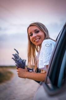 A young blonde Caucasian woman in a white dress in a lavender field. In a field of cultivation of the lavender product in Navarra