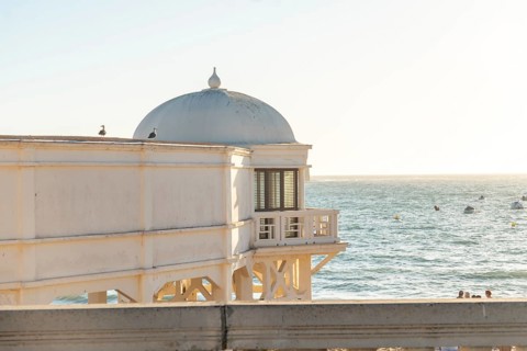 Moorish white building on the beach of La Caleta in the city of Cadiz at sunset. Andalusia