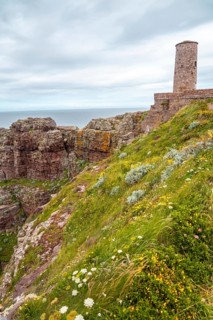 The beautiful coastline next to the Phare Du Cap Frehel is a maritime lighthouse in Cotes-dÂ´Armor France . At the tip of Cap Frehel