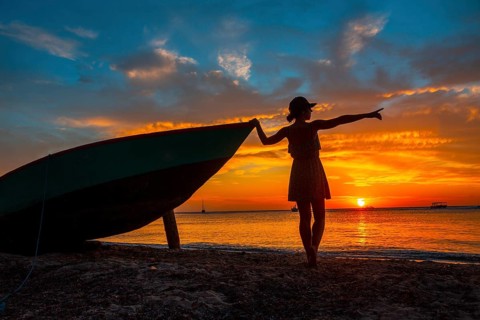 A young woman in a boat at Roatan Sunset from West End. Honduras