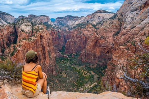 A young woman enjoying the views of Zion from the Angels Landing Trail in Zion National Park