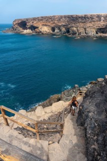 A young woman on the stairs of the path towards the caves of Ajuy