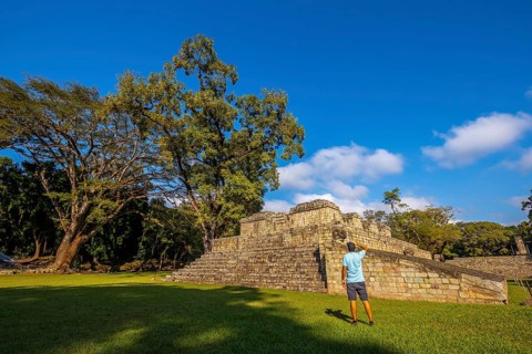 A young man looking at a pyramid in the temples of Copan Ruinas. Honduras