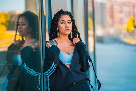 Urban session. Young woman of black ethnicity with long braids and with tattoos