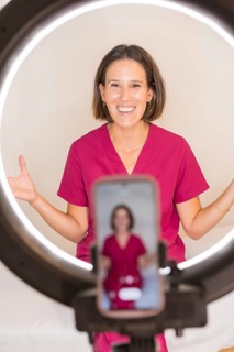 Vertical photo of a female doctor nutritionist recording a video blog with the mobile