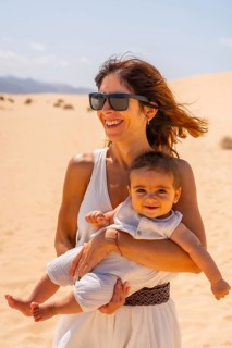 Young mother with her son very happy in the dunes of the Corralejo Natural Park