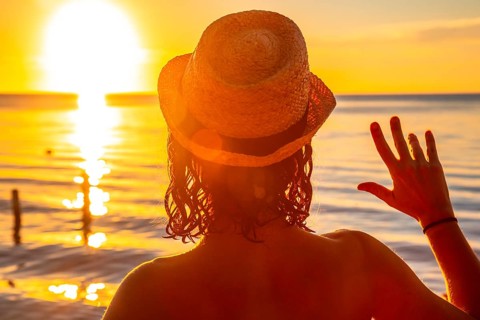 A young girl with a hat on a sunset in Roatan. Honduras