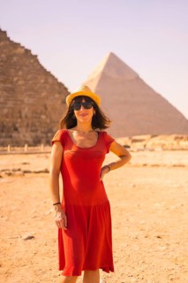 Portrait of a young girl in red dress at the pyramid of Cheops the largest pyramid. The pyramids of Giza the oldest funerary monument in the world. In the city of Cairo
